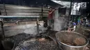 Pekerja memasak daun cincau saat memproduksi cincau hitam di Jakarta, Kamis (9/5/2019). Pabrik yang berdiri sejak 80-an ini mampu memproduksi cincau hitam hingga 1.000 kaleng/kotak per hari, jauh meningkat dari produksi bulan biasa yang hanya 300 kaleng per hari. (merdeka.com/Iqbal S. Nugroho)