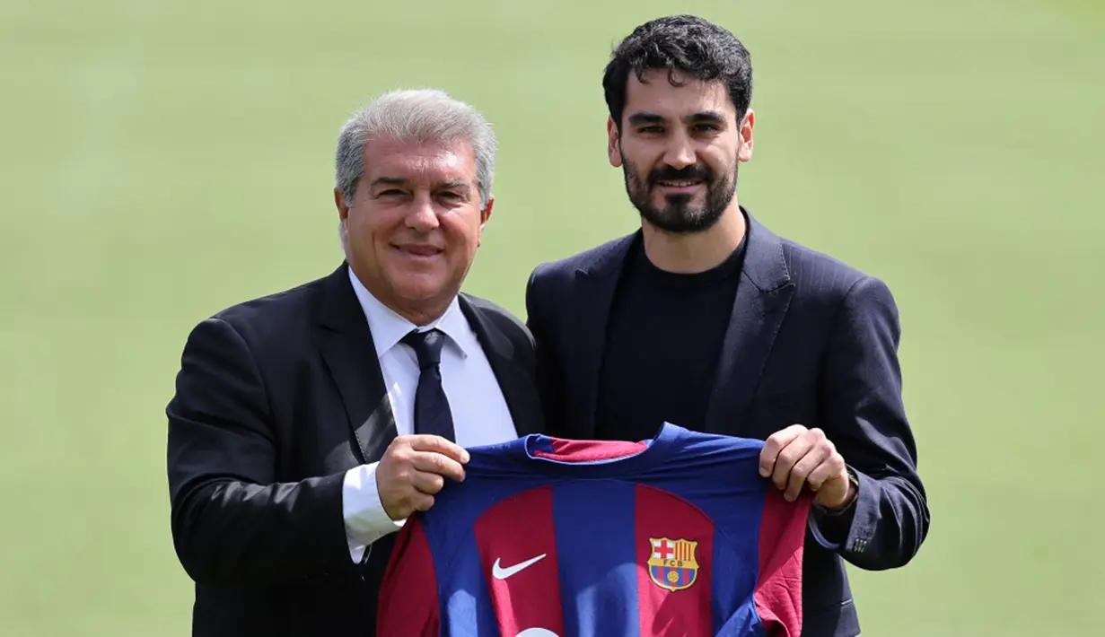 Gelandang baru FC Barcelona Ilkay Gundogan (kanan) berfoto bersama Presiden FC Barcelona Joan Laporta saat presentasi resminya di tempat latihan Joan Gamper, Sant Joan Despi, Spanyol, Senin (17/7/2023). Ilkay Gundogan resmi diperkenalkan Barcelona. (LLUIS GENE/AFP)