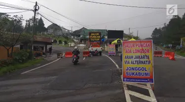 Papan penutupan arus lalu lintas terpasang di jalan Cimacan, Kabupaten Cianjur, Jawa Barat, Rabu (14/2). Setelah ditutup sejak 5 Februari lalu karena longsor, kawasan puncak Bogor sampai Cianjur menjadi seperti kota mati. (Liputan6.com/Achmad Sudarno)