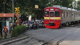 Kereta api melintas di kawasan Lenteng Agung, Jakarta, Kamis (14/3). Untuk mengurai kemacetan, Pemprov DKI Jakarta akan membangun jalan layang (fly over) berbentuk tapal kuda di perlintasan tersebut. (Liputan6.com/Immanuel Antonius)