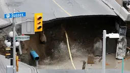 Penampakan sinkhole besar di Rideau Street, Ottawa, Kanada, Rabu (8/6). Lubang besar itu menyebabkan bocornya pipa gas dan penghuni di beberapa bangunan di jantung ibukota Kanada itu pun terpaksa dievakuasi. (REUTERS/Chris Wattie)