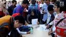 Sejumlah warga mengisi formulir untuk membayar pajak kendaraan bermotor di samsat keliling di car free day, Jakarta, Minggu (27/8). Caranya cukup menggunakan STNK dan membayar pajak sesuai yang tertera. (Liputan6.com/Angga Yuniar)