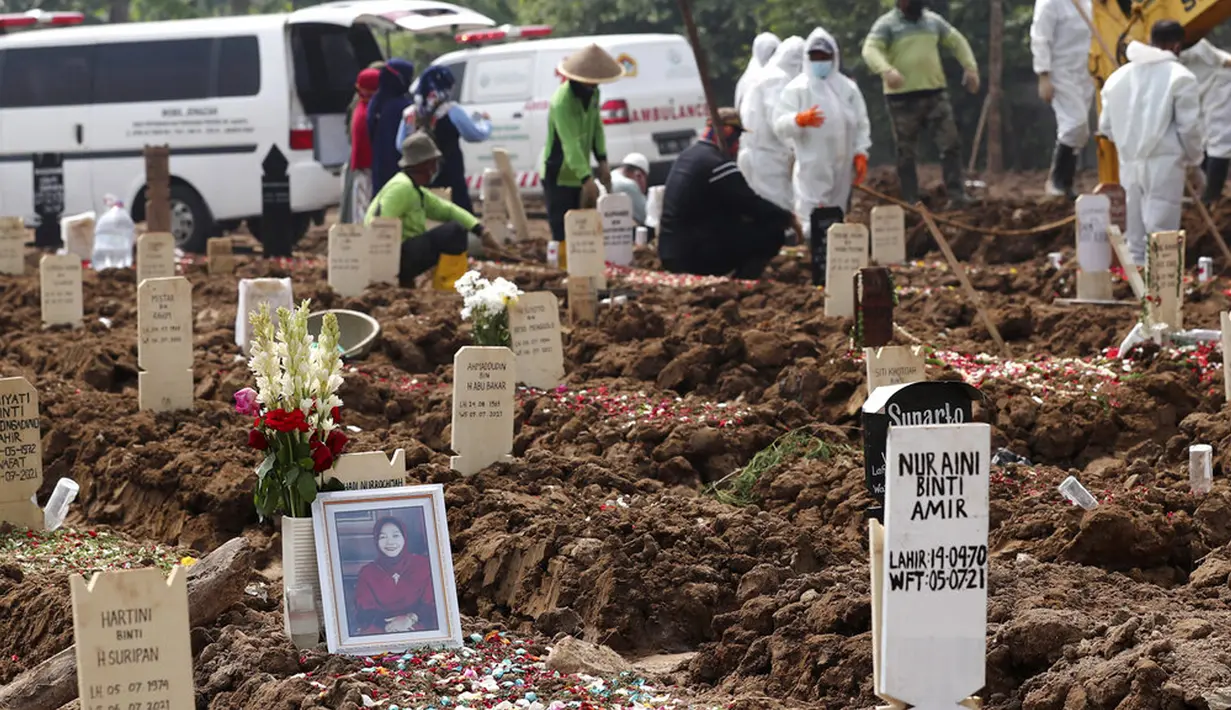 Potret seorang wanita diletakkan di kuburannya di TPU Rorotan yang diperuntukkan bagi mereka yang meninggal karena COVID-19, Jakarta, Rabu (7/7/2021). Indonesia menghadapi gelombang kedua COVID-19. (AP Photo/Tatan Syuflana)