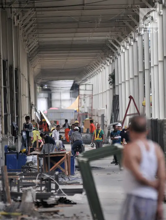 Aktivitas pekerja saat menyelesaikan pembangunan Skybridge Tanah Abang, Jakarta, Minggu (14/10). Jembatan yang menghubungkan Stasiun Tanah Abang dengan Pasar Blok G tersebut rencananya akan diresmikan pada 15 Oktober 2018. (Merdeka.com/Iqbal Nugroho)