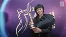 Penyanyi Yura berpose memenggang piala usai meraih penghargaan Anugerah Musik Indonesia (AMI) Awards 2017 di Teater Garuda TMII, Jakarta, Kamis (16/11). (Liputan6.com/Herman Zakharia)