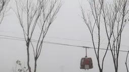 Gondola bergerak maju dalam cuaca bersalju di daerah pegunungan yang menghadap ke ibukota Teheran, Iran (18/12/2021). (AP Photo/Vahid Salemi)