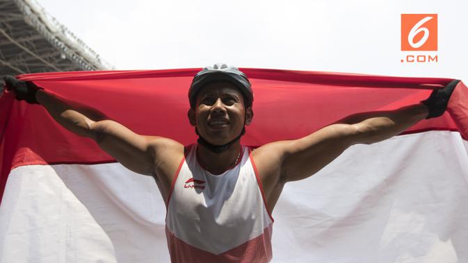 Pebalap kursi roda Indonesia, Jaenal Aripin, melakukan selebrasi usai meraih medali perak pada Asian Para Games cabang atletik nomor balap kursi roda 200 meter T 54 di SUGBK, Jakarta, Jumat (12/10). (Bola.com/Vitalis Yogi Trisna)