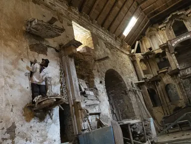 Gembala Alpaca Esteban Taipe memanjat mimbar di gereja terbengkalai di kota hantu Santa Barbara, Peru, Kamis(2/12/2021). Pada masa penjajahan Spanyol, Santa Barbara pernah menjadi tambang merkuri terbesar di Amerika. (AP Photo/Franklin Briceño)