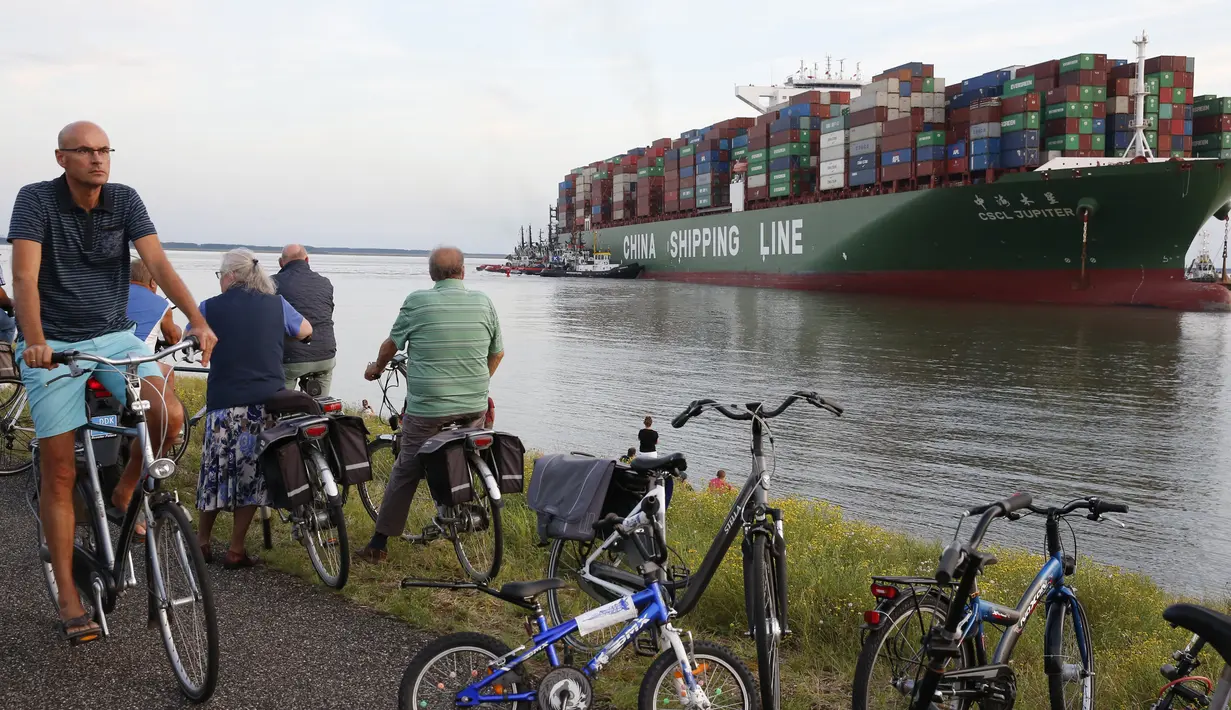 Pengendara sepeda melihat kapal kontainer CSCL Jupiter Hong Kong yang terdampar di muara Westerschelde di dekat kota Bath di Belanda setelah insiden grounding (14/8).  (AFP PHOTO/Belga/Kristof Van Accom/Belgium Out)
