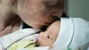 Kateryna Suharokova mencium putranya yang baru lahir, Makar di ruang bawah tanah rumah sakit bersalin yang diubah menjadi bangsal medis dan digunakan sebagai shelter bom di Mariupol, Ukraina, Senin (28/2/2022). Bayi itu lahir di tengah invasi militer Rusia ke Ukraina. (AP Photo/Evgeniy Maloletka)