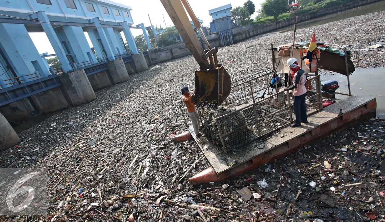 Petugas membersihkan sampah di Pintu Air Marunda Hilir, Jakarta, Selasa (17/5). Perilaku buruk warga buang sampah sembarangan menyebabkan sampah selalu menumpuk di pintu air tersebut, meskipun setiap hari dibersihkan. (Liputan6.com/Immaniel Antonius)