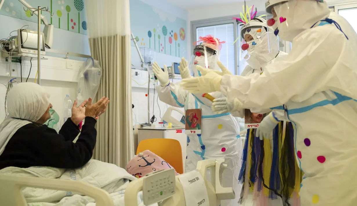 Para badut medis menghibur seorang pasien COVID-19 di ruang perawatan Ziv Medical Center di Kota Safed, Israel utara, pada 19 November 2020. (Xinhua/JINI/Erez Ben Simon)