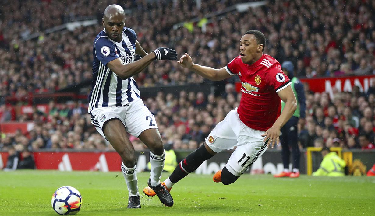 Pemain West Bromwich, Allan Nyom (kiri) berebut bola dengan pemain Manchester United, Anthony Martial pada lanjutan Premier League di Old Trafford, Manchester,(15/4/2018). Manchester United kalah 0-1. (Nick Potts/PA via AP)