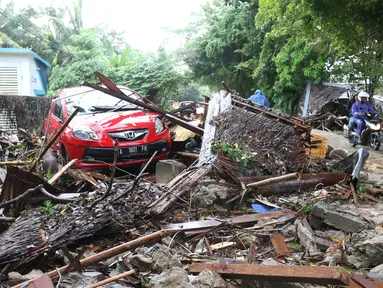 Sebuah mobil di antara puing-puing dari bangunan yang rusak setelah tsunami menerjang kawasan Anyer, Banten, Minggu (23/12). Tsunami menerjang pantai di Selat Sunda, khususnya di daerah Pandenglang, Lampung Selatan, dan Serang. (Liputan6.com/Angga Yuniar)