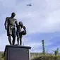 Helikopter terbang melewati patung untuk mengenang Kobe Bryant dan putrinya, Gianna di Calabasas, California, Rabu (26/1/2022). Patung itu dibawa seniman Dan Medina, di jalan setapak dekat lokasi Bryant, putrinya dan tujuh orang lainnya tewas dalam kecelakaan helikopter pada 2020. (AP/Ashley Landis)