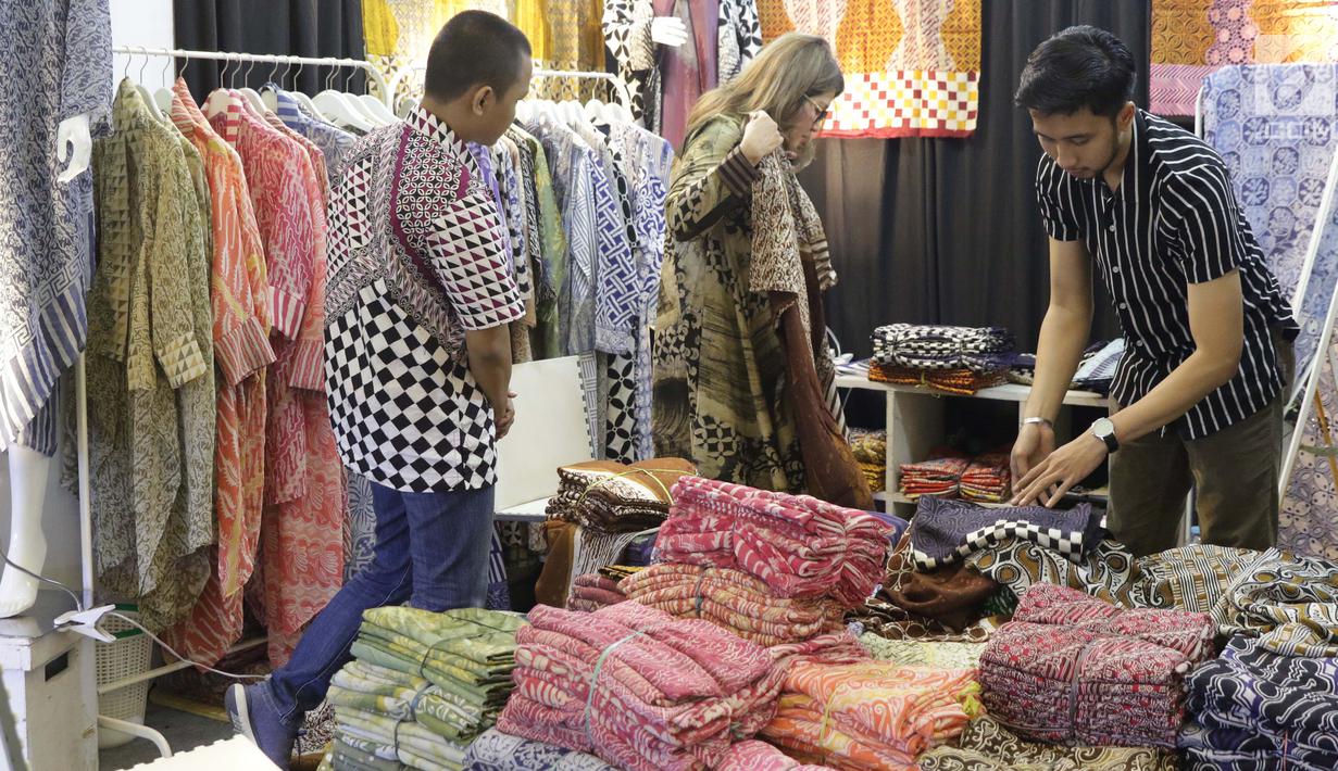 Pengunjung melihat-lihat stand pameran Gelar Kain Unggulan Nusantara di Jakarta Convention Center, Jumat (27/9/2019). Ratusan model kain dipamerkan dalam Gelar Kain Unggulan Nusantara yang berlangsung hingga Minggu, 29 September mendatang. (Liputan6.com/Helmi Fithriansyah)