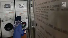Seorang ibu rumah tangga menaruh cucian di sebuah laundry koin di Jakarta, Sabtu (8/6). Pada libur Lebaran, jasa laundry ramai didatangi konsumen, terutama oleh mereka yang ditinggal mudik asisten rumah tangganya. (merdeka.com/Imam Buhori)