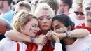 Tiga orang fans saling berpelukan usai timnas Inggris gagal melaju ke final Piala Dunia di Hyde Park, London, Rabu (11/7/2018). Kroasia menang 2-1 atas Inggris. (AP/Matt Dunham)