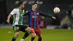 Penyerang Barcelona Robert Lewandowski mengontrol bola saat bek Real Betis Luiz Felipe bertahan pada semifinal Piala Super Spanyol di King Fahd International Stadium, Riyadh pada Jumat (13/1/2023) dini hari WIB. Barcelona menang adu penalti 4-2 atas Real Betis setelah bermain imbang 2-2 lewat perpanjangan waktu. (AP Photo/Hussein Malla)