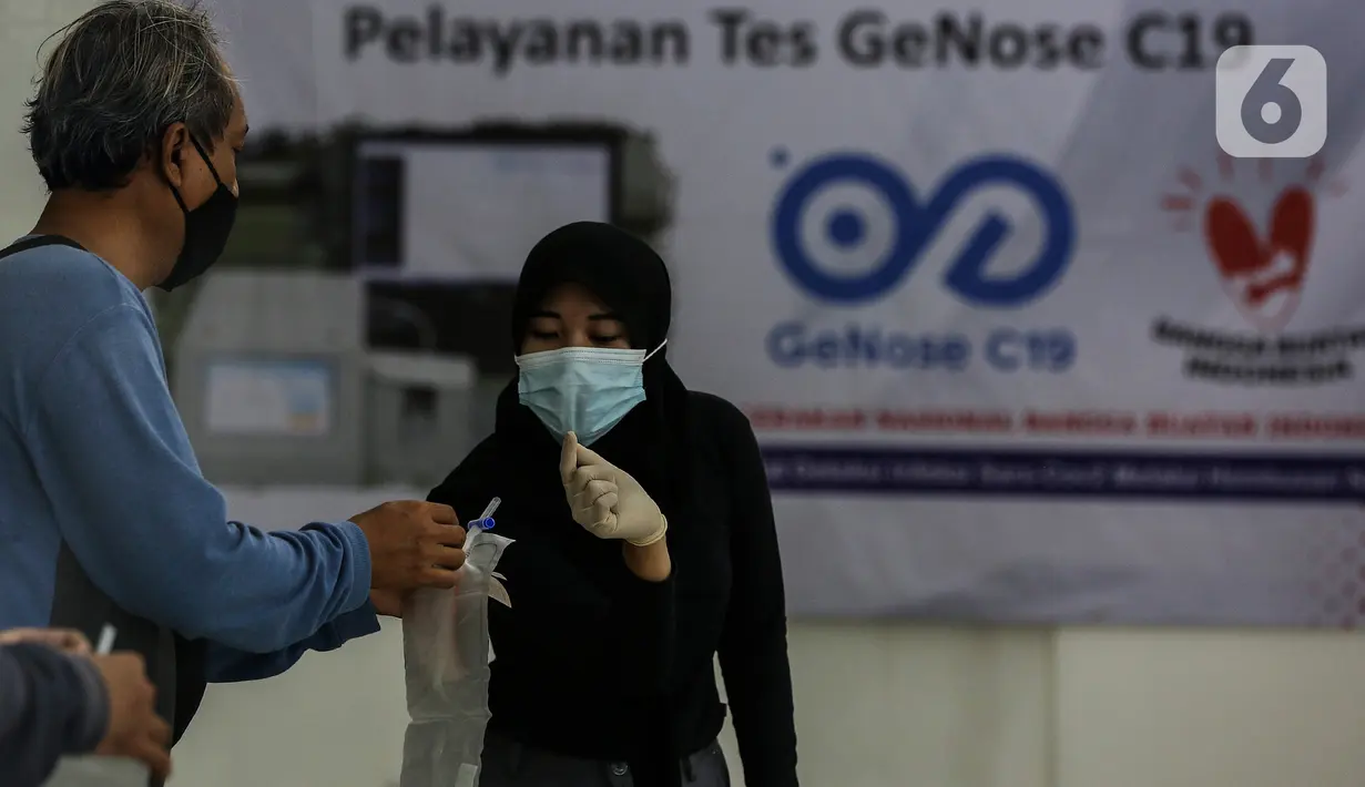Petugas menjelaskan pemakaian alat tes deteksi COVID-19 dengan metode GeNose C19 kepada calon penumpang kereta di stasiun Gambir, Jakarta, Senin (12/2/2021). Stasiun Gambir mulai menerapkan layanan pemeriksaan GeNose C19 untuk penumpang yang hendak berpergian keluar kota (Liputan6.com/Johan Tallo)