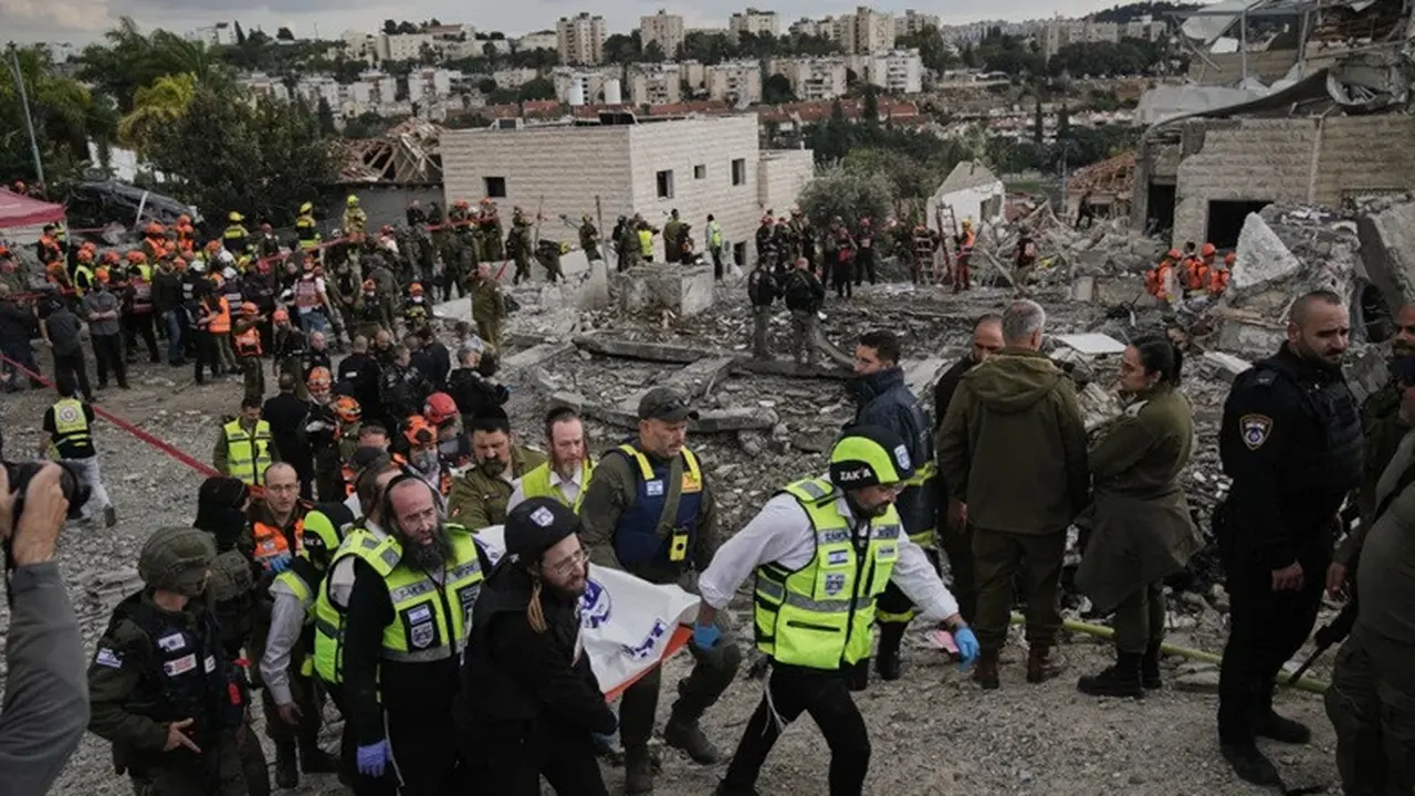 Petugas penyelamat dan personel militer mengangkat jenazah korban di lokasi serangan rudal Iran di Beit Shemesh, Israel, Minggu (1/3/2026), setelah beberapa orang tewas akibat serangan tersebut.