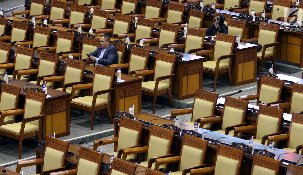 Dua anggota DPR menghadiri rapat paripurna Masa Sidang I Periode 2019-2020 di antara bangku yang tak terisi di Kompleks Parlemen, Senayan, Jakarta, Kamis (22/8/2019). Rapat yang membahas RUU APBN Tahun 2020 beserta nota keuangannya itu hanya dihadiri 55 orang. (Liputan6.com/Johan Tallo)