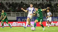 Gelandang serang Persebaya, Bruno Moreira (kanan), berduel dengan bek PSIS, Joao Ferarri, pada lanjutan BRI Liga 1 2024/2025 di Stadion Gelora Bung Tomo, Surabaya, Rabu (12/3/2025) malam WIB. (Bola.com/Aditya Wany)