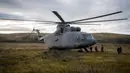 Wartawan media asing turun dari helikopter MI 26 militer Rusia ketika mereka tiba untuk meliput latihan militer Vostok-2018 (Timur 2018) di Tsugol, Siberia timur, Kamis (13/9). Rusia dan China memulai latihan militer bersamanya. (AFP/Mladen Antonov)