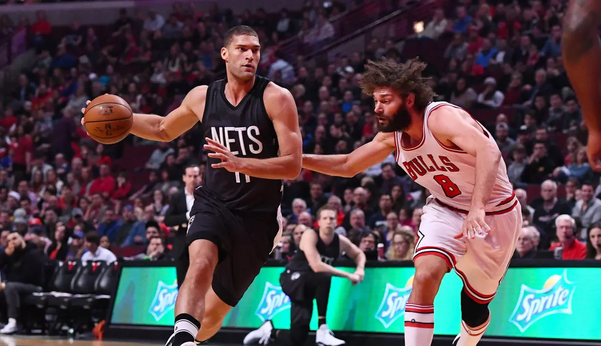 Pemain Nets, Brook Lopez (11) berusaha melewati hadangan saudara kembarnya pemain Chicago Bulls, Robin Lopez (8) pada lanjutan NBA basketball game, (28/12/2016) di United Center.  Bulls menang 101-99. (Reuters/Mike DiNovo-USA TODAY Sports)
