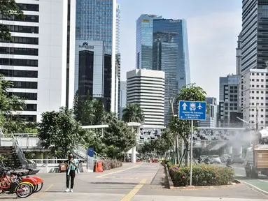 Kendaraan petugas PMI menyemprotkan disinfektan di kawasan Sudirman, Jakarta, Selasa (1/9/2020). Gubernur DKI Jakarta Anies Baswedan mengeluarkan Kepgub Nomor 879 Tahun 2020 yang berisi aturan perpanjangan PSBB Transisi secara otomatis dengan syarat tertentu. (merdeka.com/Iqbal S. Nugroho)