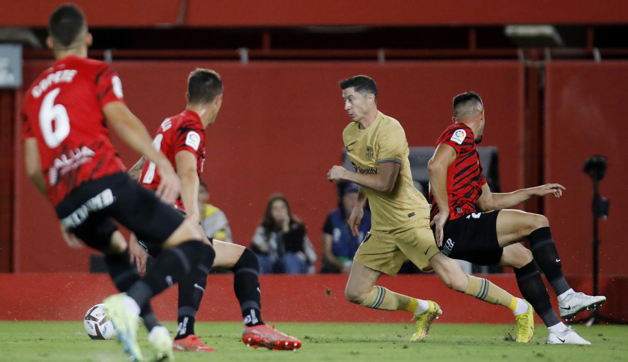 Mendapat umpan Ansu Fati, Lewandowski yang berada di depan kotak penalti mampu mengecoh dua pemain sebelum menembak ke tiang jauh gawang Mallorca. (AP/Francisco Ubilla)