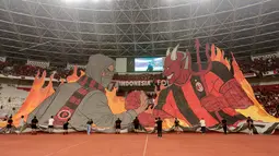Suporter AC Milan membentangkan tifo raksasa saat memberikan dukungan kepada tim kesayangannya sebelum laga melawan Chelsea pada ajang Indonesia Super Cup 2026 di Stadion Utama Gelora Bung Karno (SUGBK), Jakarta, Sabtu (8/8/2026). Tifo bergambar sosok berjabat tangan dengan karakter iblis yang identik dengan julukan Rossoneri tersebut menjadi daya tarik di tribun dan semakin menyemarakkan atmosfer pertandingan di hadapan puluhan ribu penonton. (KapanLagi.com/Budy Santoso)