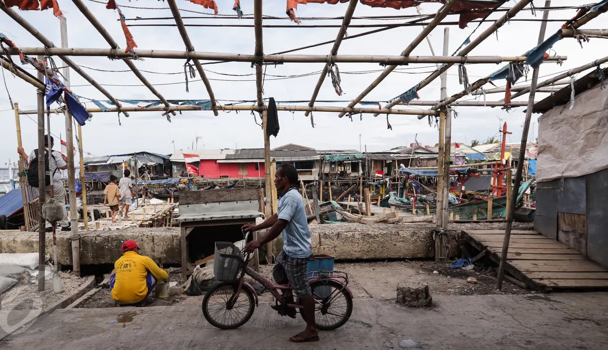 Seorang warga mengendarai sepeda di Tempat Pelelangan Ikan Cilincing, Jakarta Utara, Rabu (8/2). (Fery Pradolo/Liputan6.com)