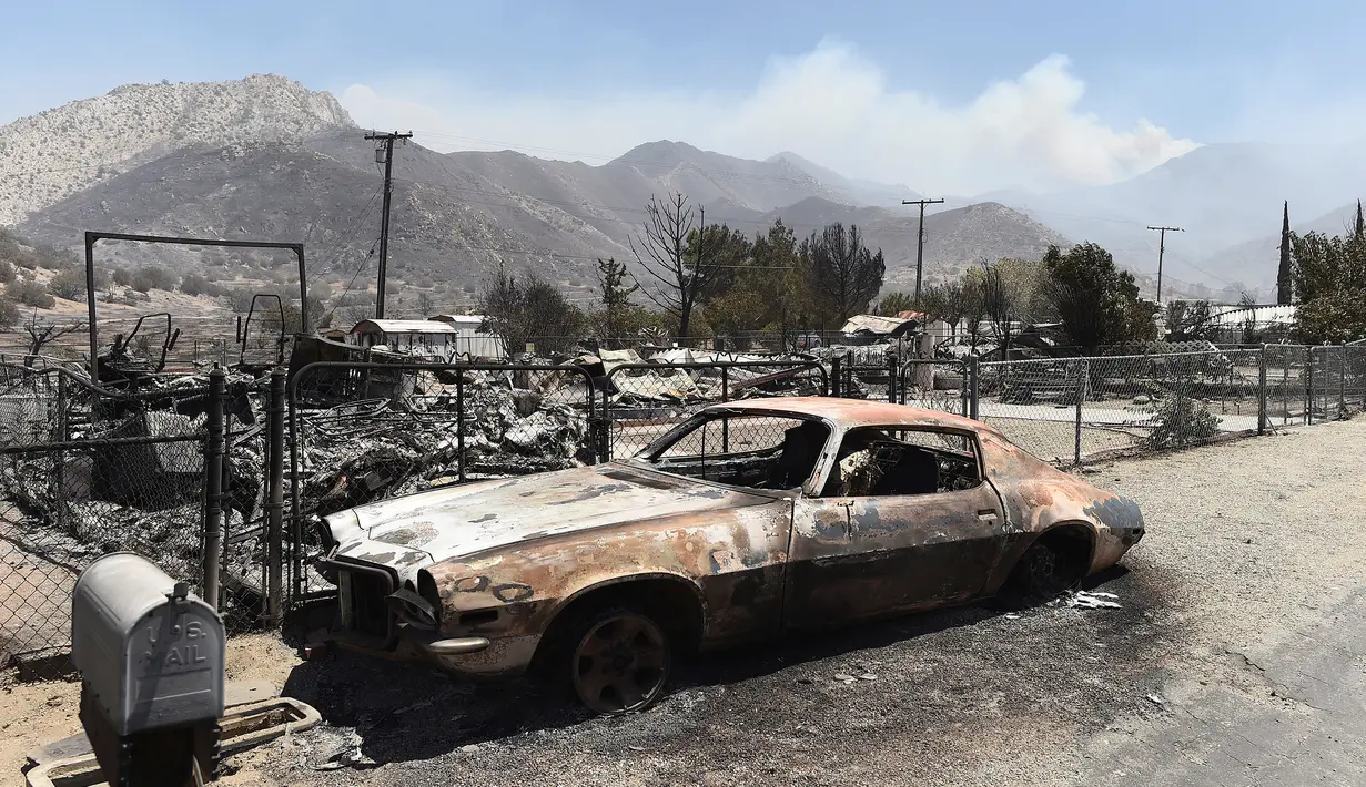 Sebuah mobil hangus terbakar di Erskine pasca kebakaran dahsyat di sepanjang South Lake, California, AS (24/6). Musibah yang disebabkan oleh kebakaran hutan ini telah menghanguskan sebuah perkampungan warga di California. (REUTERS/Noah Berger)