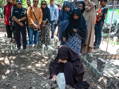 Bibi (kanan bawah) dari penyelam Syachrul Anto yang meninggal dunia kala melakukan evakuasi jatuhnya pesawat Lion Air PK-LQP, berdoa saat pemakaman di Surabaya, Jawa Timur, Sabtu (3/11). Syachrul Anto meninggal karena dekompresi. (JUNI KRISWANTO/AFP)