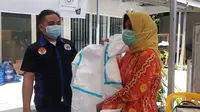 Pemateri dari Bapelkes saat memeragakan penggunaan hazmat dalam pelatihan keamanan bagi sukarelawan 'Roa Jaga Roa' yang membantu penanganan Covid-19 di Palu, Jumat (20/8/2021). (Foto: Heri Susanto/ Liputan6.com).