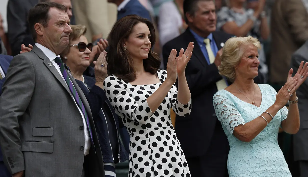 Kate Middleton (tengah) bertepuk tangan setelah petenis asal Inggris, Andy Murray berhasil mengalahkan petenis Rusia, Alexander Bublik pada pertandingan babak pertama Wimbledon di London, Inggris, (3/7). (AFP Photo/Adrian Dennis)