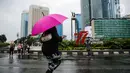 Warga berjalan sambil menggunakan payung saat Car Free Day (CFD) di kawasan Bundaran HI, Jakarta, Minggu (2/10/2022). Meski diguyur hujan deras sejak pagi, warga tetap antusias untuk tetap berolahraga saat CFD. (Liputan6.com/Faizal Fanani)