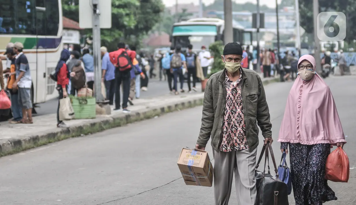 Pemudik membawa barang mereka seusai turun dari bus antarkota antarprovinsi (AKAP) di Terminal Kampung Rambutan, Jakarta, Minggu (23/5/2021). Hingga sore ini pemudik dari kota di Jawa Barat, Tengah, Timur, dan Sumatera terus berdatangan di Terminal Kampung Rambutan. (merdeka.com/Iqbal S Nugroho)