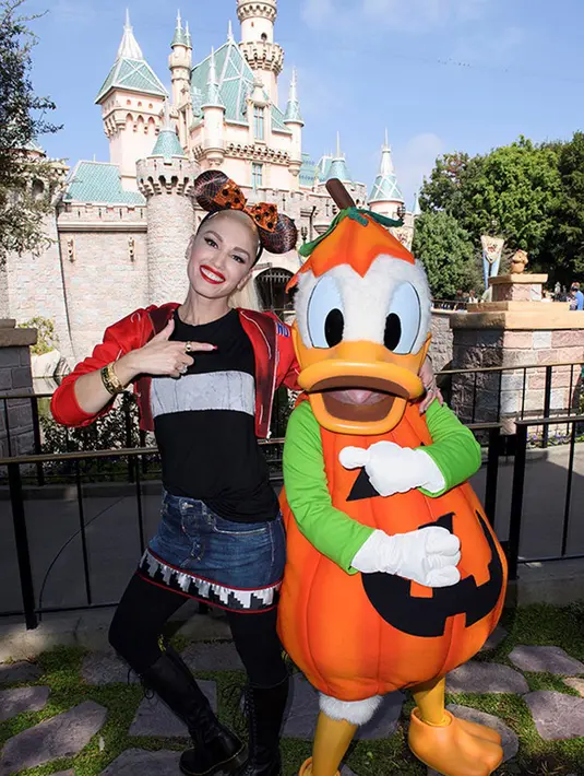 Tidak berkostum seram, Gwen Stefani merayakan Halloween dengan mengunjungi Disneyland dan memakai hias kepala berbentuk kuping Minney Mouse dan berfoto dengan Donald Duck. (doc.Hollywoodlife.com)