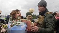 Mantan juara dunia tinju kelas berat Ukraina Wladimir Klitschko (kanan) mengucapkan selamat kepada anggota Pasukan Pertahanan Teritorial Ukraina Lesia Ivashchenko dan Valerii Fylymonov yang baru menikah dalam upacara pernikahan di pos pemeriksaan di Kiev, 6 Maret 2022. (AP/Efrem Lukatsky)