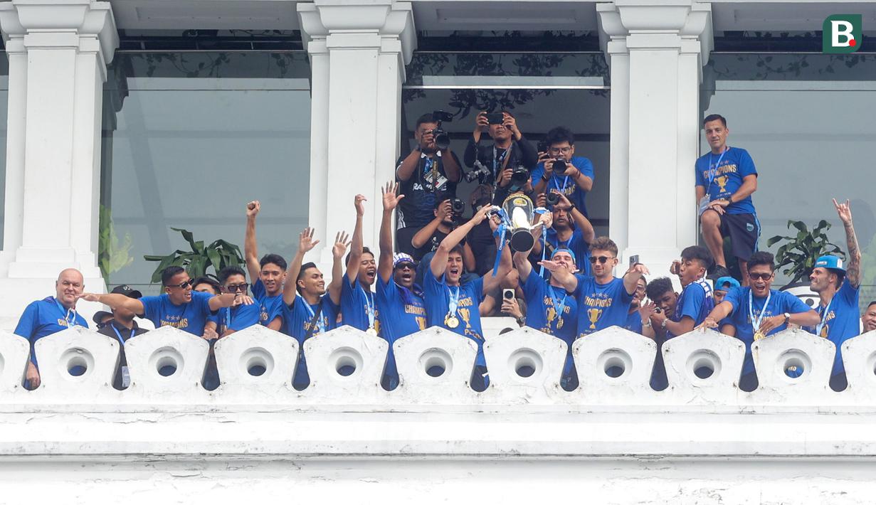 Pemain Persib Bandung mengangkat trofi saat merayakan pesta juara di Gedung Sate, Bandung, Minggu (25/5/2025). (Bola.com/M Iqbal Ichsan)