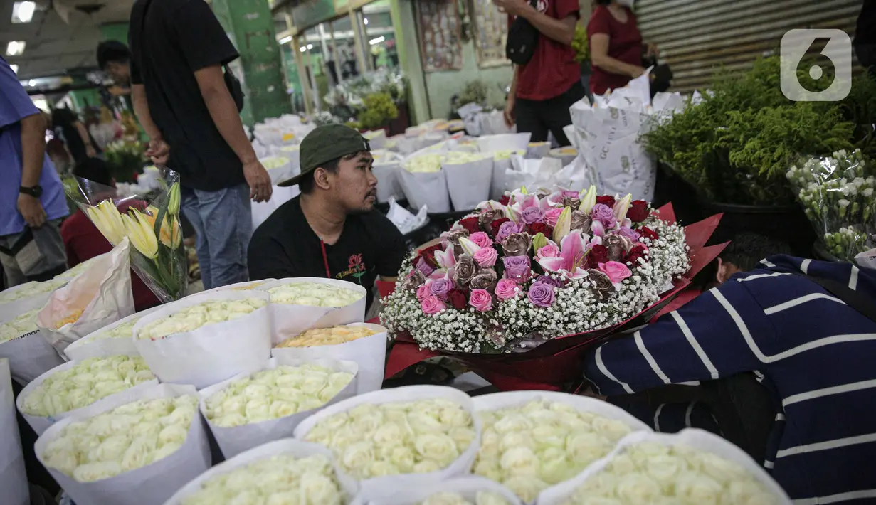 Perajin menata buket atau karangan bunga di Pasar Bunga Rawa Belong, Jakarta, Senin (14/2/2022). Perajin buket setempat mengaku permintaan pesanan karangan bunga yang biasa dihadiahkan saat hari kasih sayang atau Valentine Day tersebut menurun. (Liputan6.com/Faizal Fanani)