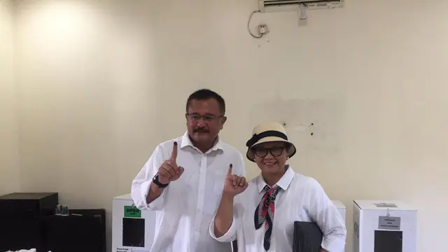 Menlu Retno Marsudi dan suami menujukkan jarinya yang sudah diberi tinta usai memberikan hak suaranya di TPS Pesona Khayangan, Kota Depok, Jawa Barat (Liputan6.com/Teddy Tri Setio Berty)