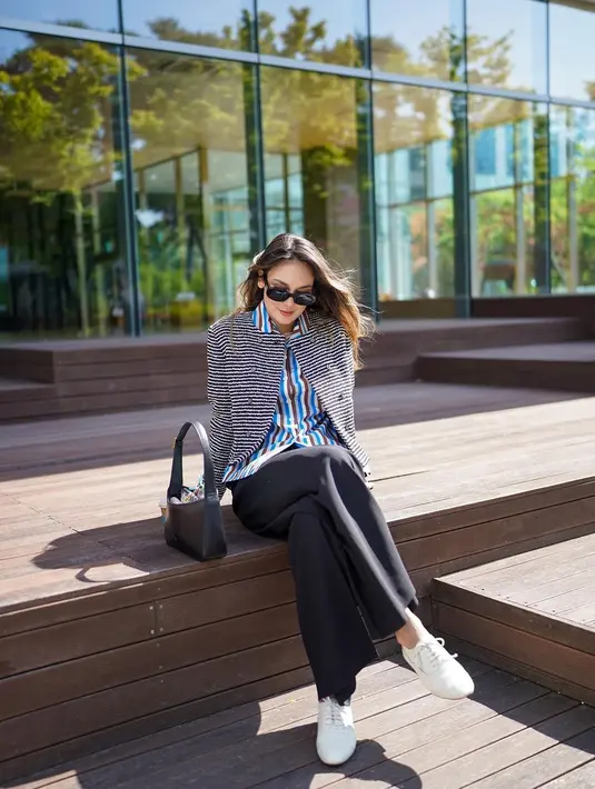 Masih di Korea Selatan, kali ini Luna Maya memadukan striped vertical shirt dengan striped horizontal blazer serta basic pants warna hitam. Gayanya itu disempurnakan dengan shoulder bag warna hitam. (Instagram/lunamaya).