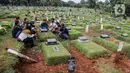 Sejumlah orang saat berziarah ke makam di Tempat Pemakaman Umum (TPU) Pondok Ranggon, Jakarta, Minggu (04/04/21). Menjelang bulan Ramadan umat muslim melakukan ziarah kubur untuk mendoakan keluarga dan kerabatnya yang telah wafat. (Liputan6.com/Faizal Fanani)