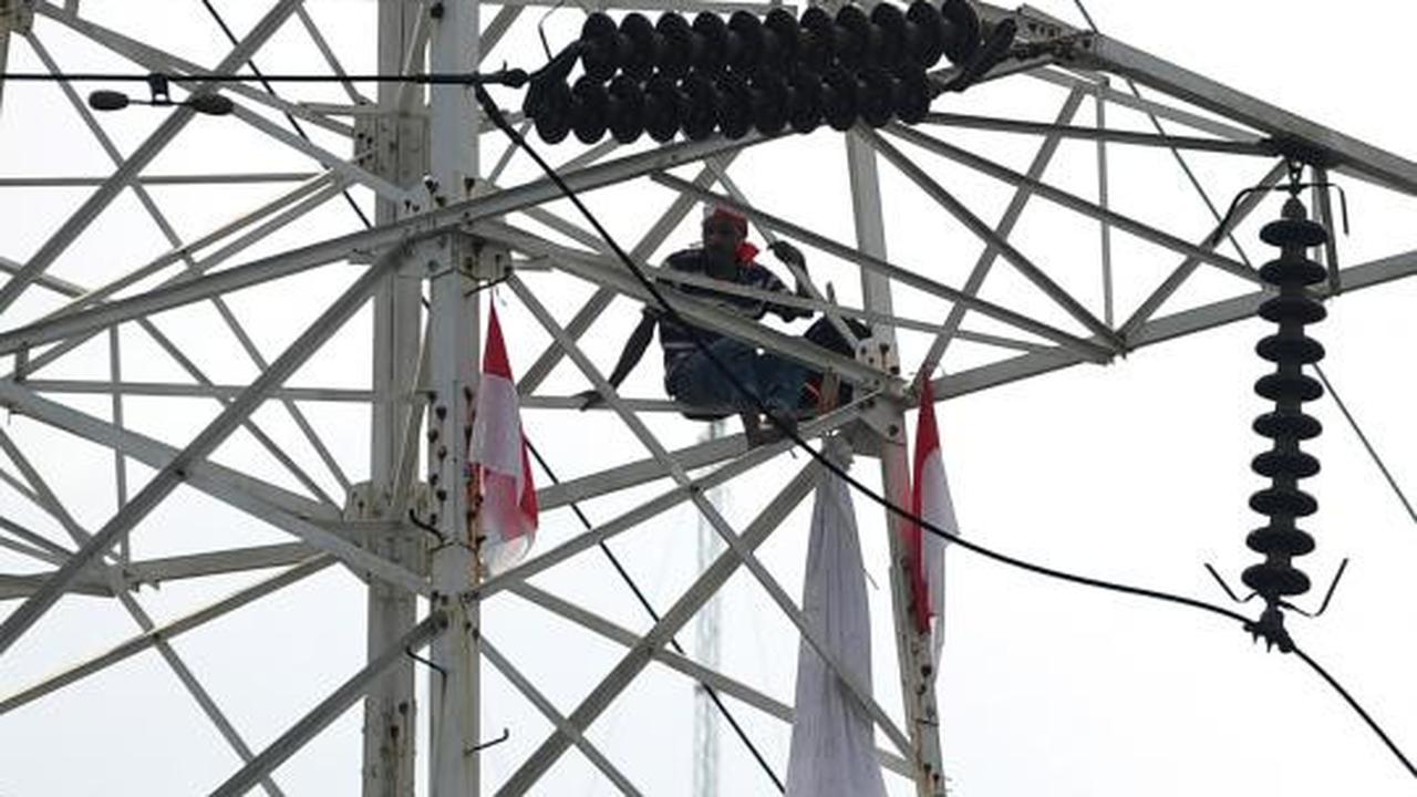 Pria berpakaian pocong di atas tower SUTET