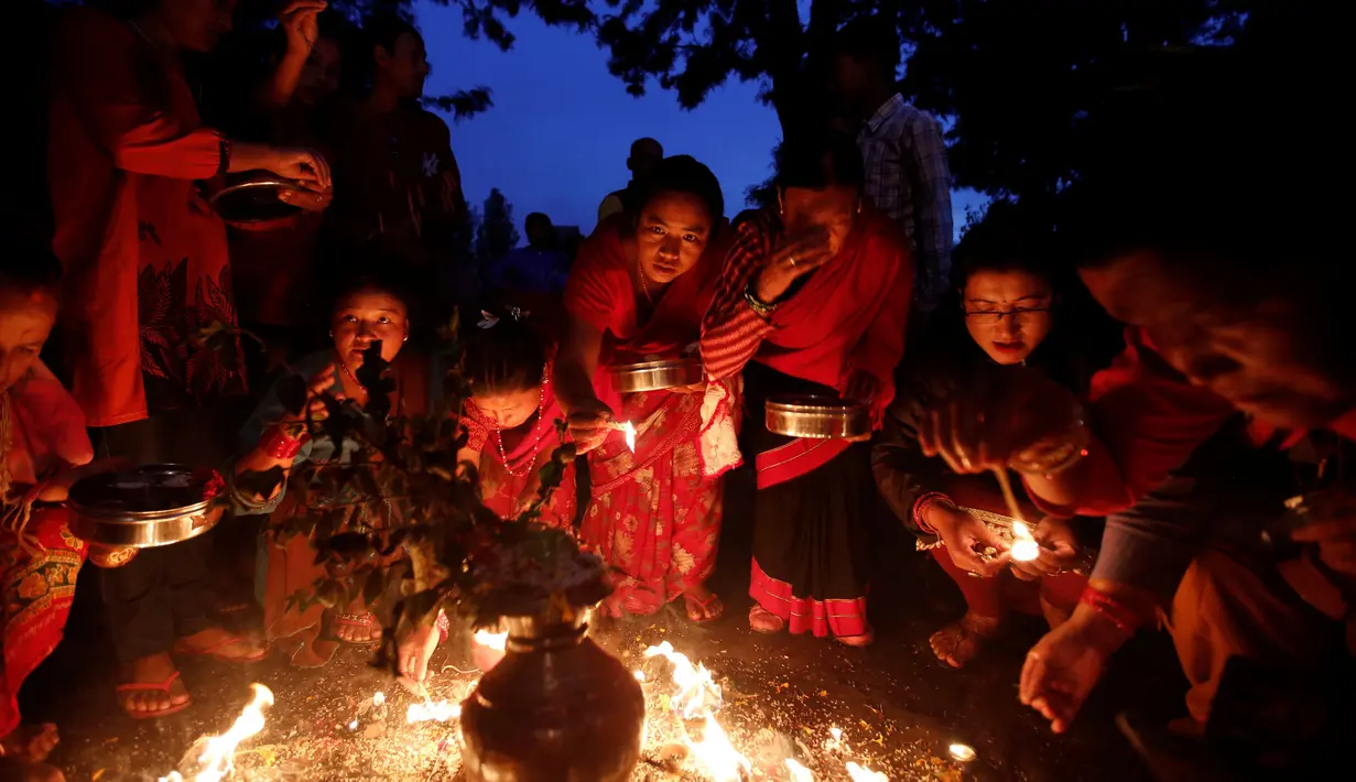 Sejumlah wanita Nepal menyalakan api dalam ritual Dashian yang diadakan di Bhaktapur, Nepal (11/10). Dashian merupakan festival agama Hindu yang diadakan 5 tahun sekali di Bhaktapur, Nepal. (REUTERS/Navesh Chitrakar)