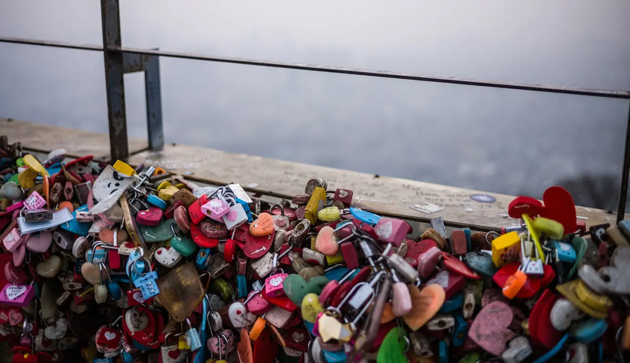 Gembok yang ditinggalkan pengunjung terlihat menempel di pagar dekat Menara Namsan sementara pemandangan latar belakang tertutup kabut pada hari yang tercemar di Seoul, Korea Selatan, Rabu (15/12/2021). (AFP/Anthony Wallace)