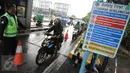 Petugas mengarahkan pengendara sepeda motor masuk menuju tol dalam kota di pintu tol Taman Mini 2, Jakarta, Kamis (21/4). Hujan deras yang mengguyur sejak semalam membuat sejumlah jalan di Ibu Kota tergenang banjir. (Liputan6.com/Angga Yuniar)
